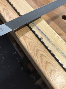 I used the drill press with the carbide drill bit to put in the holes for the loop retainer. Since I didn't have anything to really place the starting point, I clamped the blade to a 2x4, and just set the speed to the lowest and drilled them out. Then of course - I sharpened and set the teeth.